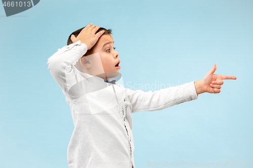 Image of The young attractive teen boy looking suprised isolated on blue