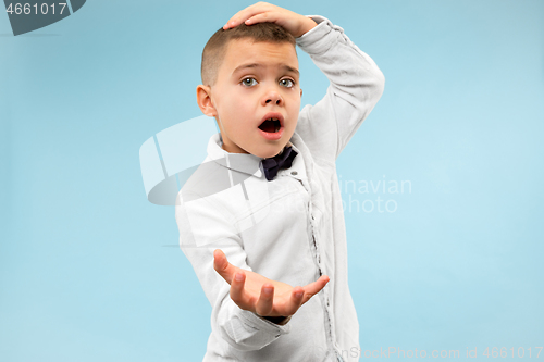 Image of The young attractive teen boy looking suprised isolated on blue