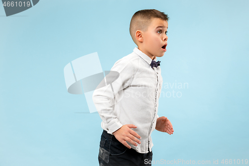 Image of The young attractive teen boy looking suprised isolated on blue