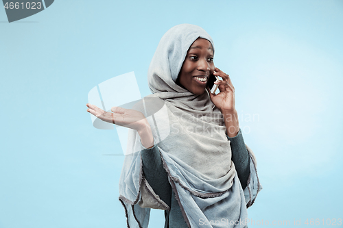 Image of The beautiful young black muslim girl wearing gray hijab, with a happy smile on her face.