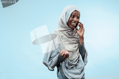 Image of The beautiful young black muslim girl wearing gray hijab, with a happy smile on her face.