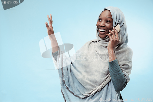 Image of The beautiful young black muslim girl wearing gray hijab, with a happy smile on her face.