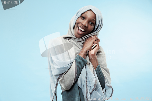 Image of The beautiful young black muslim girl wearing gray hijab, with a happy smile on her face.