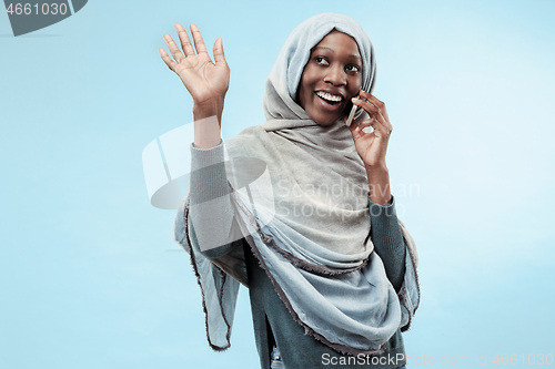 Image of The beautiful young black muslim girl wearing gray hijab, with a happy smile on her face.