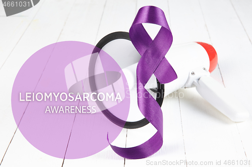 Image of The purple ribbon on white wooden background