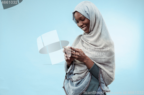 Image of The beautiful young black muslim girl wearing gray hijab, with a happy smile on her face.