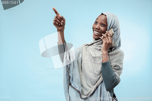 Image of The beautiful young black muslim girl wearing gray hijab, with a happy smile on her face.