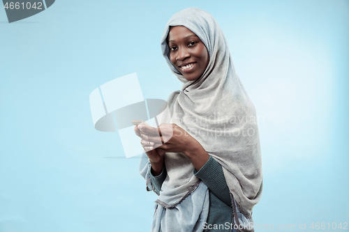 Image of The beautiful young black muslim girl wearing gray hijab, with a happy smile on her face.