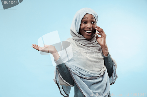 Image of The beautiful young black muslim girl wearing gray hijab, with a happy smile on her face.