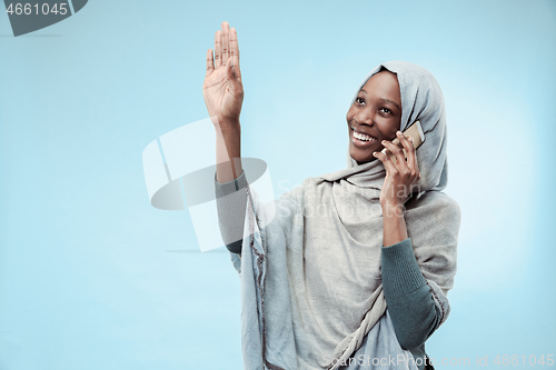 Image of The beautiful young black muslim girl wearing gray hijab, with a happy smile on her face.