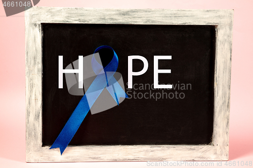 Image of Colon cancer awareness poster. Blue ribbon made of dots on white background. Medical concept.