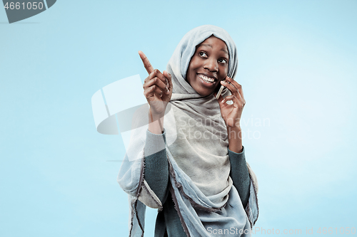 Image of The beautiful young black muslim girl wearing gray hijab, with a happy smile on her face.