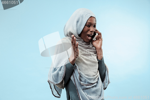 Image of The beautiful young black muslim girl wearing gray hijab, with a happy smile on her face.