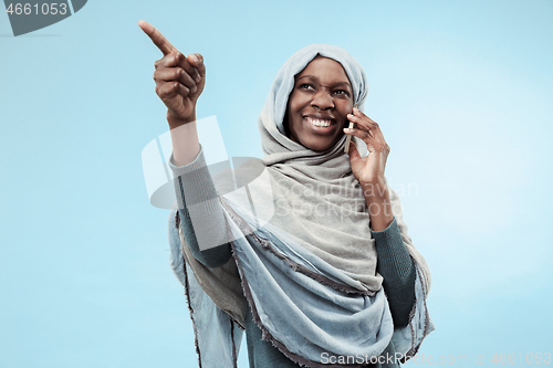 Image of The beautiful young black muslim girl wearing gray hijab, with a happy smile on her face.