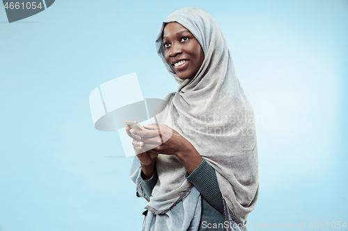 Image of The beautiful young black muslim girl wearing gray hijab, with a happy smile on her face.