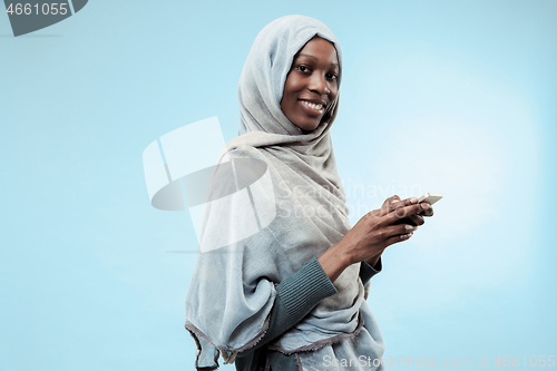 Image of The beautiful young black muslim girl wearing gray hijab, with a happy smile on her face.