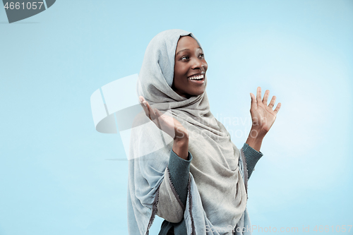 Image of The beautiful young black muslim girl wearing gray hijab, with a happy smile on her face.