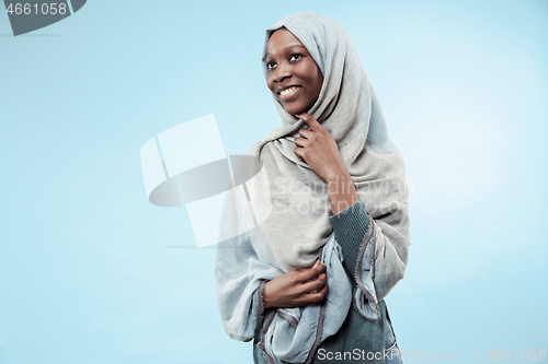 Image of The beautiful young black muslim girl wearing gray hijab, with a happy smile on her face.