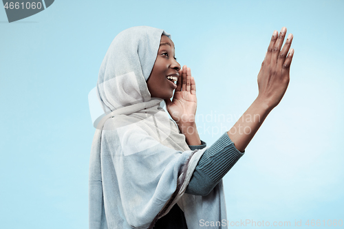 Image of Isolated on blue young africasual woman shouting at studio