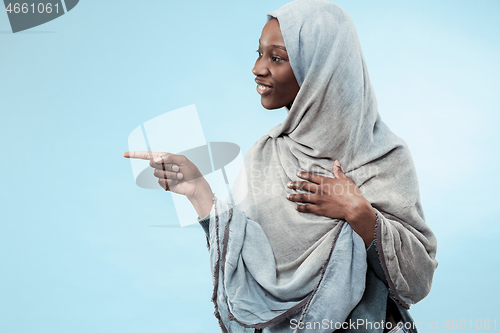 Image of The beautiful young black muslim girl wearing gray hijab, with a happy smile on her face.