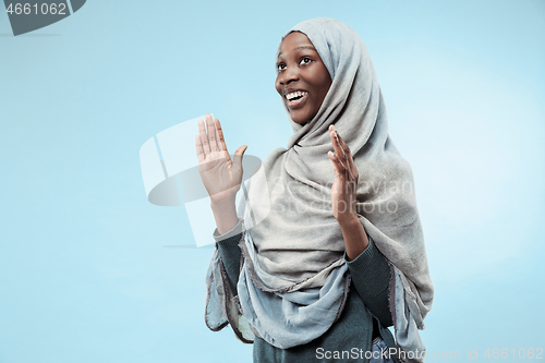 Image of The beautiful young black muslim girl wearing gray hijab, with a happy smile on her face.