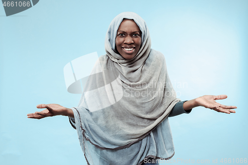 Image of The beautiful young black muslim girl wearing gray hijab, with a happy smile on her face.