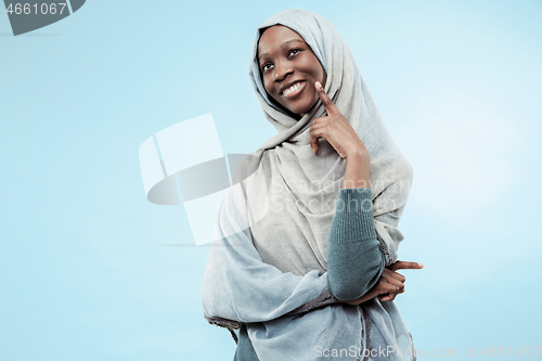 Image of The beautiful young black muslim girl wearing gray hijab, with a happy smile on her face.