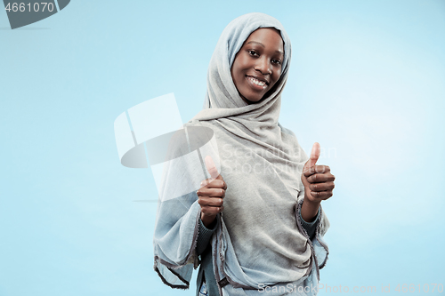 Image of The beautiful young black muslim girl wearing gray hijab, with a happy smile on her face.