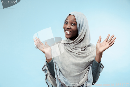 Image of The beautiful young black muslim girl wearing gray hijab, with a happy smile on her face.