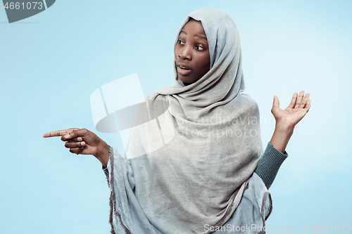 Image of The beautiful young black muslim girl wearing gray hijab, with a happy smile on her face.