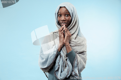 Image of The beautiful young black muslim girl wearing gray hijab, with a happy smile on her face.