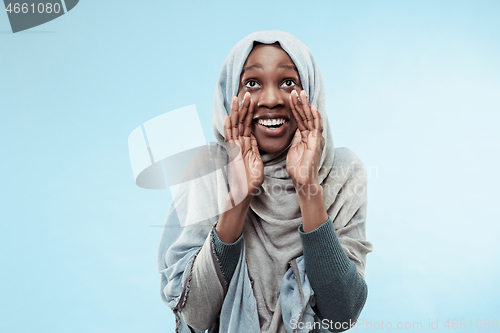 Image of Isolated on blue young africasual woman shouting at studio