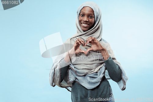 Image of The beautiful young black muslim girl wearing gray hijab, with a happy smile on her face.