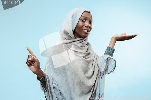 Image of The beautiful young black muslim girl wearing gray hijab, with a happy smile on her face.