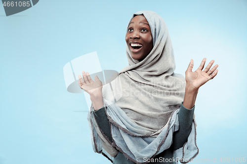 Image of The beautiful young black muslim girl wearing gray hijab, with a happy smile on her face.