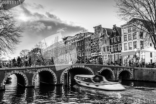 Image of Beautiful tranquil scene of city of Amsterdam at dusk. Bicycles along the street and on the bridge over the canal.