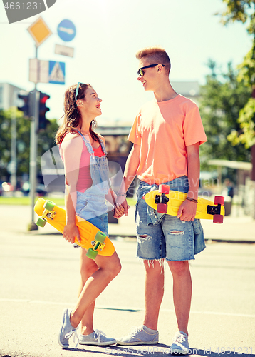 Image of teenage couple with skateboards on city street