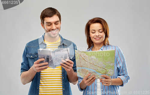 Image of happy couple of tourists with city guide and map
