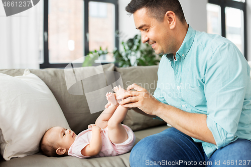 Image of middle aged father playing with baby at home