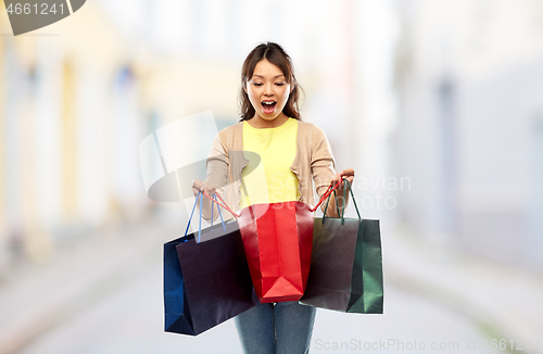 Image of happy asian woman with shopping bags