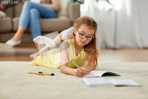 Image of student girl writing to notebook at home