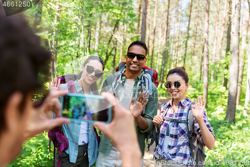 Image of friends with backpacks being photographed on hike