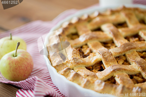 Image of apple pie in baking mold on wooden table