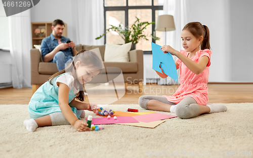 Image of happy sisters doing arts and crafts at home