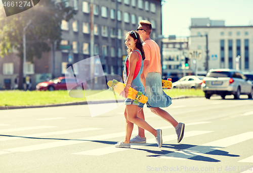 Image of teenage couple with skateboards on city street