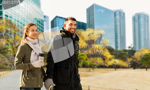 Image of happy couple walking along autumn tokyo city