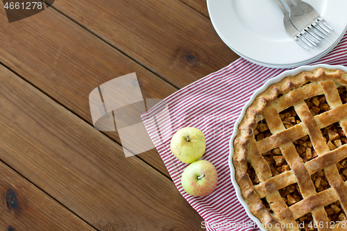 Image of apple pie in baking mold on wooden table