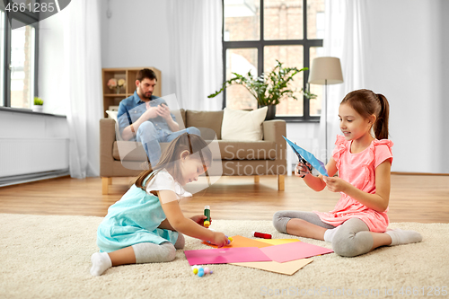 Image of happy sisters doing arts and crafts at home