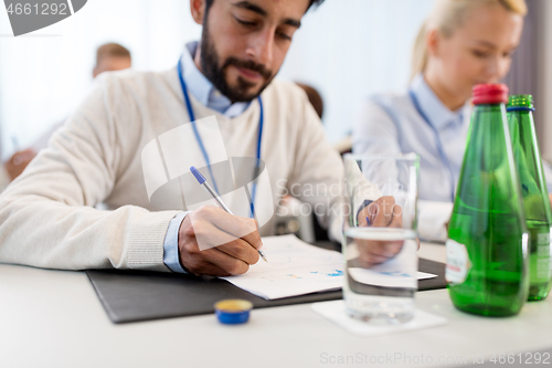 Image of businessman with papers at business conference