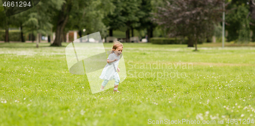 Image of happy little baby girl running at park in summer